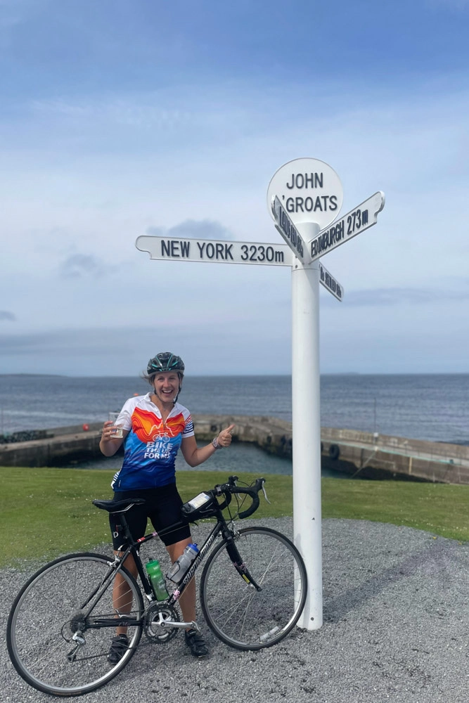 Celebrating completing the adventure in John O'Groats at the famous John O'Groats sign post.